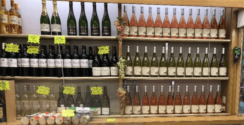 Étagères de bouteilles de vin rouge, rosé et blanc dans une cave et boutique de vins à Vitry-sur-Seine.