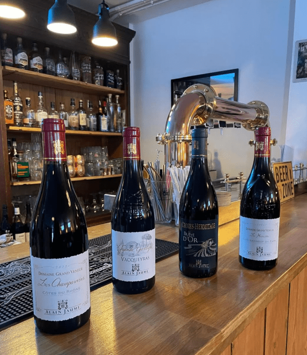 Bouteilles de vins rouges sélectionnées au Cellier Groupe Pianeta à Vitry-sur-Seine sur le comptoir du caviste.